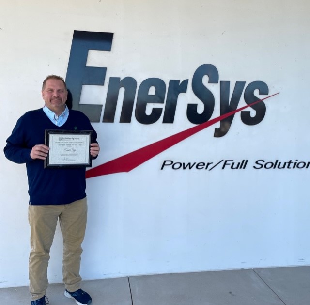 Employee Joe holding a certificate in his hands